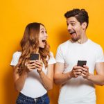 woman and man holding phones and enjoying