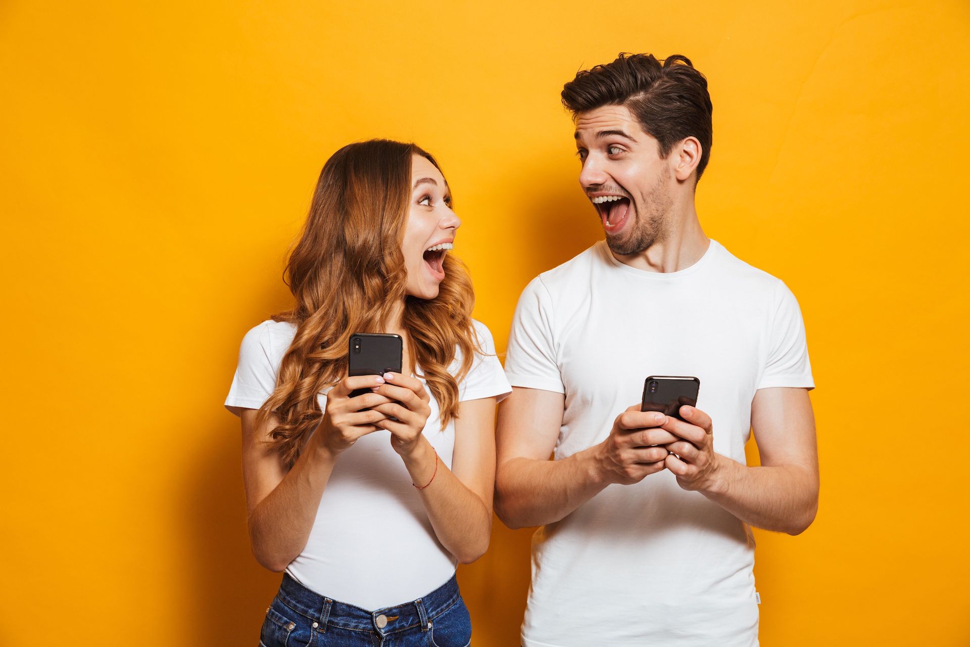 woman and man holding phones and enjoying